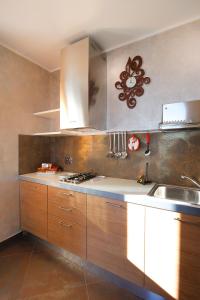 een keuken met houten kasten en een wastafel bij Poggio dei Gorleri in Diano Marina