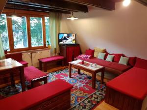 a living room with red couches and a tv at Snow Angel Jahorina in Jahorina