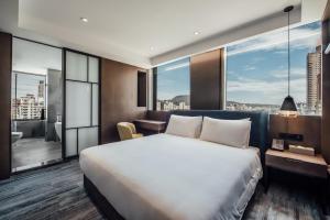 a hotel room with a bed and a large window at Harbour 10 Hotel in Kaohsiung