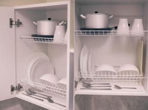 a white cabinet with dishes and utensils in it at Ars Hotel on Krasnie Vorota in Moscow
