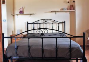 a black metal bed in a room with shelves at mansarda fiorita in Abatemarco