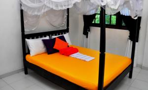 a bedroom with a black and orange bed with pillows at Bon Accord Mirissa in Mirissa