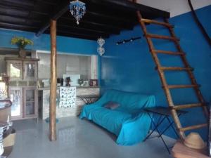 a blue room with a couch and a ladder at Auberge de la Plage in Kep
