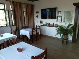 a restaurant with two tables and chairs and a tv at B&BSheshalliu in Berat