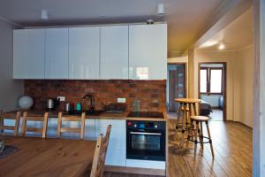 a kitchen with white cabinets and a table and chairs at Apartamenty Buczyna w Sierakowie in Sieraków