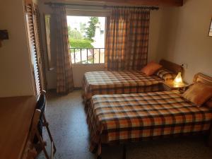 トラダンバーラにあるLlar Montagutの窓付きの客室で、ベッド2台が備わります。
