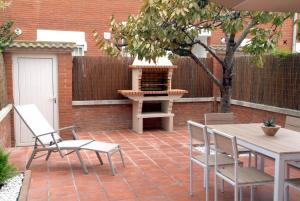 um pátio com uma mesa, cadeiras e comodidades para churrascos em Vivalidays Casa Pinell - Palafolls - Costa Barcelona em Palafolls
