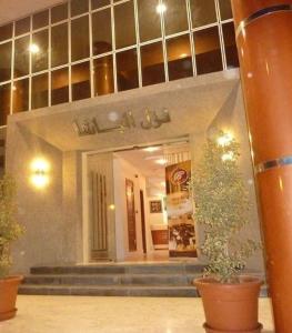 a lobby with two potted plants in a building at Pacha hotel in Sfax