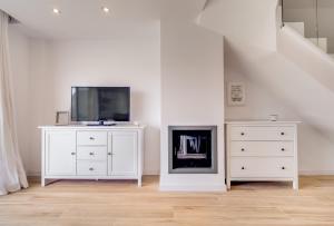 sala de estar con TV y tocador blanco en Vivalidays Elisabet, en Palafolls