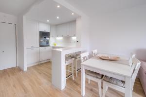 Una cocina blanca con una mesa y sillas blancas. en Vivalidays Elisabet, en Palafolls