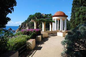 a gazebo next to the ocean with flowers at Vivalidays Josep in Blanes