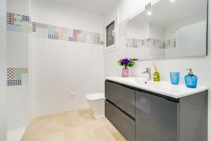 a white bathroom with a toilet and a sink at Vivalidays Josep in Blanes +14 photos