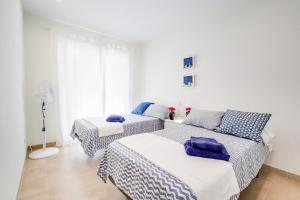 a bedroom with two beds with blue and white sheets at Vivalidays Josep in Blanes