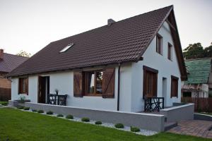 una casa bianca con tetto marrone di Apartamenty Buczyna w Sierakowie a Sieraków