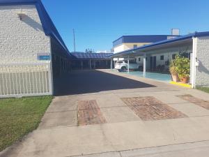 
a large white building with a blue and white checkered rug at Fitzroy Motor Inn in Rockhampton
