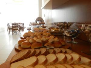 a table topped with lots of different types of bread at Casablanca Center Hotel in Petrópolis
