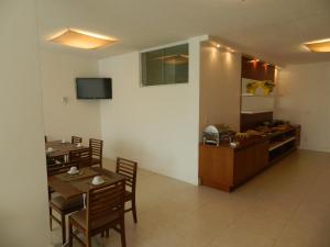 a dining room with a table and chairs and a kitchen at Casablanca Center Hotel in Petrópolis