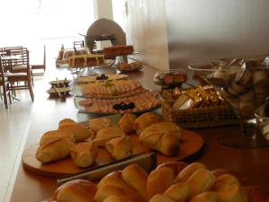 a buffet of food with bread and pastries on plates at Casablanca Center Hotel in Petrópolis