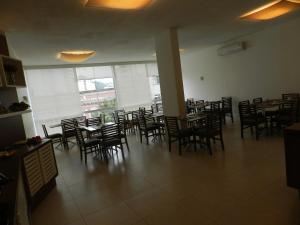 a dining room with chairs and tables and a large window at Casablanca Center Hotel in Petrópolis