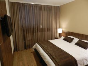 a hotel room with a bed and a television at Casablanca Center Hotel in Petrópolis