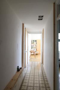 un pasillo con paredes blancas y una habitación con mesa en Apartment E.CO. Home Tarragona en Tarragona