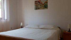 a bed in a bedroom with a picture on the wall at Adelia in Mali Lošinj