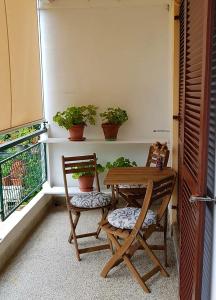 einen Tisch und Stühle auf einem Balkon mit Pflanzen in der Unterkunft Adelia in Mali Lošinj