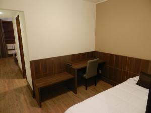 a desk in a hotel room with a bed and a desk at Casablanca Center Hotel in Petrópolis