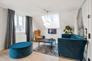 a living room with a blue couch and a chair at VANDER - Sea Story in Stavanger