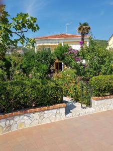 een tuin van bloemen en planten voor een huis bij Apartments Antica in Rab