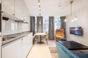 a kitchen with white cabinets and a table and chairs at VANDER - Sea Story in Stavanger
