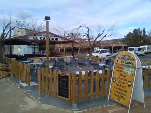 a restaurant with chairs and a sign in front of it at Hostal Restaurante el Cazador in Nuévalos