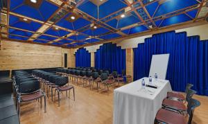 a room with chairs and a table in a room with blue curtains at Bravia Hotel Manali Inn in Manāli