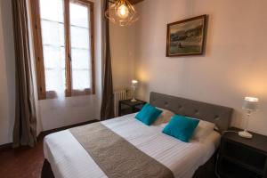 een slaapkamer met een groot bed met blauwe kussens bij Ma Petite Auberge in Castellane
