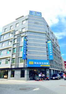 a large gray building with blue signs on it at Kaishen Sinsu Hotel in Taitung City