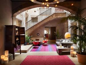 a large living room with a staircase and a couch at Hotel Neri – Relais & Chateaux in Barcelona