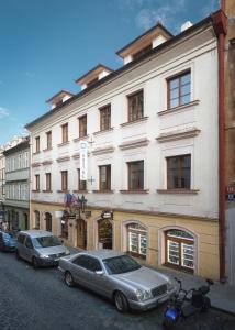dwa samochody zaparkowane przed dużym budynkiem w obiekcie Hostel Little Quarter w Pradze