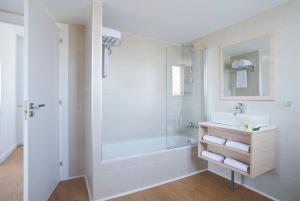 a white bathroom with a shower and a sink at Hotel Salou Beach Family Rentalmar in Salou +78 photos
