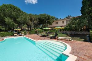 a large swimming pool with chairs and umbrellas at Dolce Vita in Campiglia Marittima