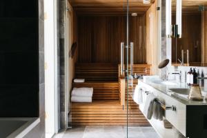 a bathroom with two sinks and a walk in shower at Hotel St. George Helsinki in Helsinki