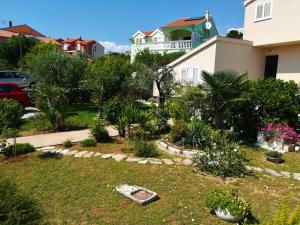 a garden in front of a house with trees and plants at Olive grove in Vodice