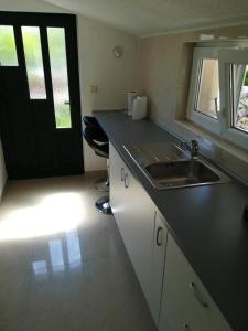 a kitchen with a sink and a black door at Olive grove in Vodice