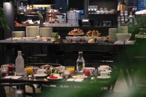 a table with plates of food and drinks on at Hotel St. George Helsinki in Helsinki