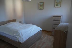 - une chambre avec un lit et une commode dans l'établissement Chalet Le Télémark, à Thollon-les-Mémises