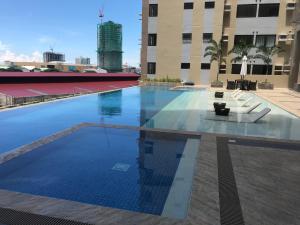 Una gran piscina en un edificio con sillas. en The Persimmon Studios Near Ayala and SM City Cebu, en Cebú