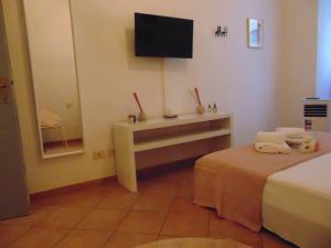 フィレンツェにあるGessi Charming Apartmentsのベッドとテレビが備わるホテルルームです。