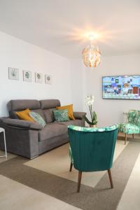 a living room with a couch and a chandelier at Chalet Vacacional Salnés Sur con PISCINA in Cambados