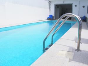 a swimming pool with blue water in a building at Moradia O Pinhal, S. Lourenço - Ericeira in Casais de São Lourenço