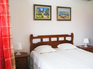 Casais de São LourençoにあるMoradia O Pinhal, S. Lourenço - Ericeiraのベッドルーム1室(ベッド1台付)が備わります。壁に2枚の写真が飾られています。