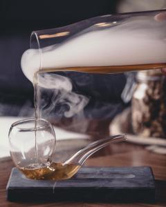 a tea kettle pouring tea into a glass cup at Hotel St. George Helsinki in Helsinki
